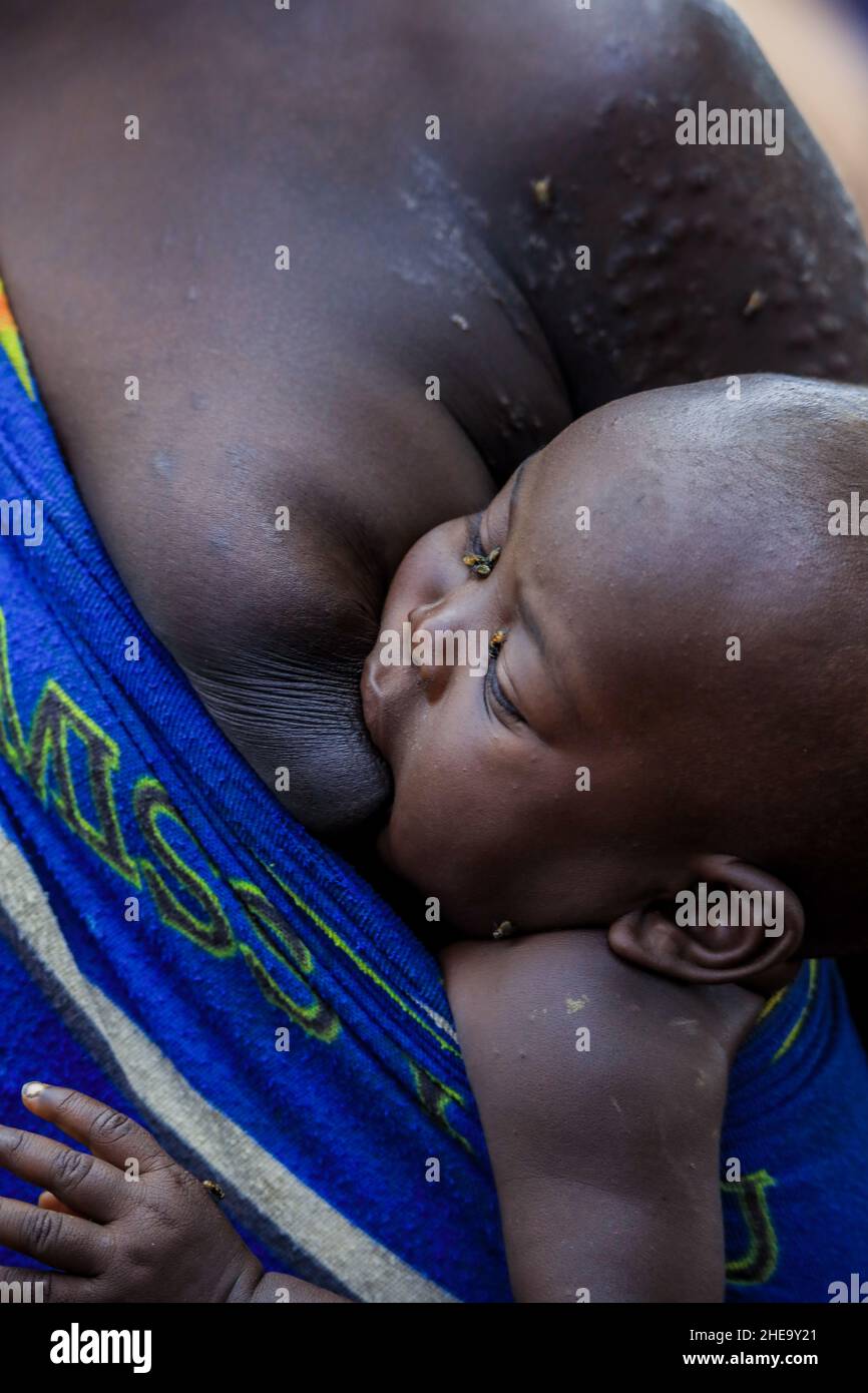 Omo River Valley, Äthiopien, November 2020, ein Kleinkind mit seiner Mutter aus dem Stamm der Mursi Stockfoto