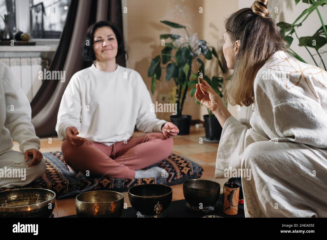 Gruppe Klangheilung, Vibrationsmassage und alternative Therapie. Psychische Gesundheit, Meditation und Entspannung. Therapeut verbrennt palo santo. Rauch von Verschmierungen Stockfoto
