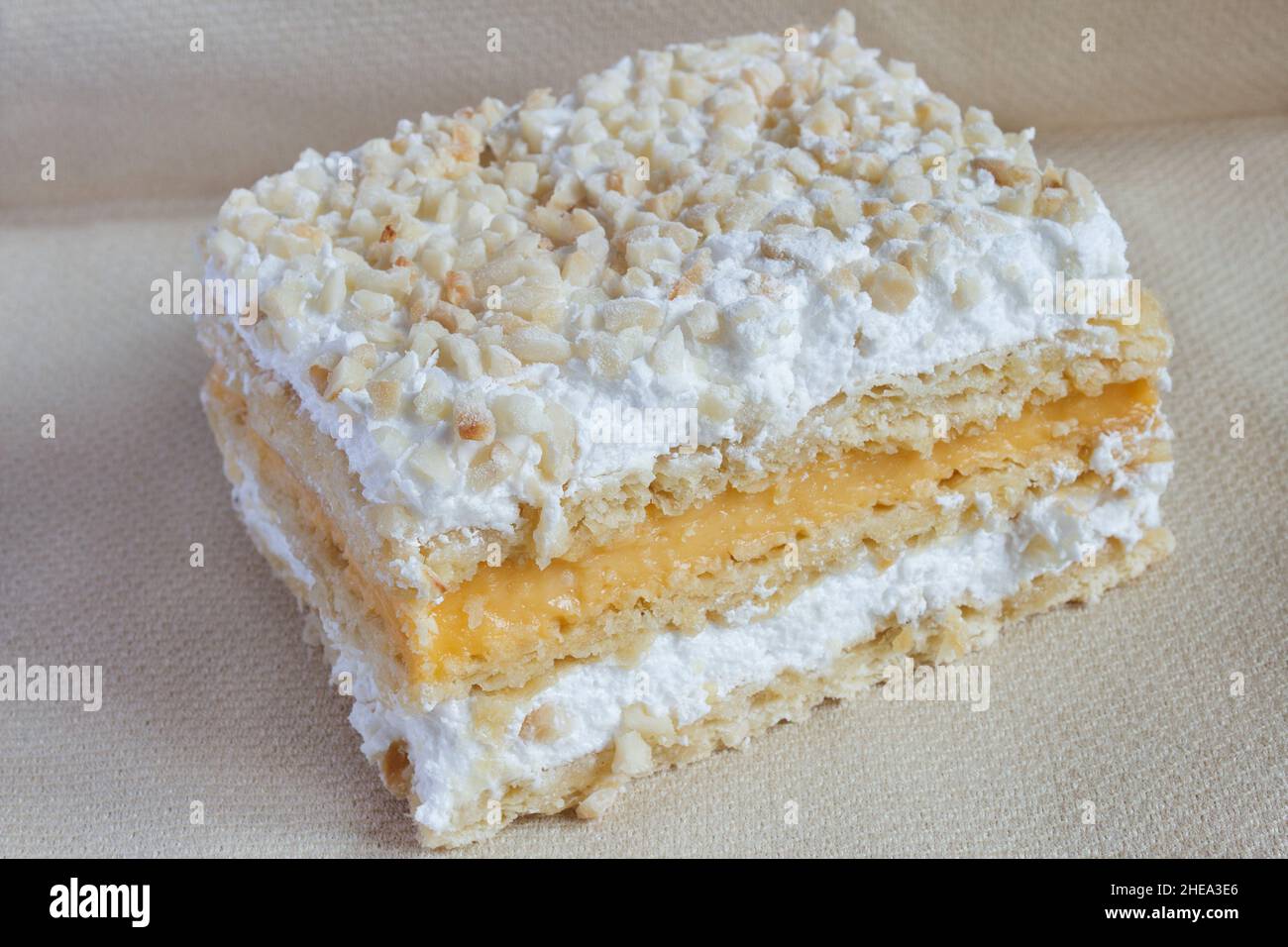Millefeuille in knusprigen überlappenden Schichten aus Blätterteig und gefüllt mit Backcreme und Baiser, gekrönt mit gerösteten gehackten Mandeln und ici Stockfoto