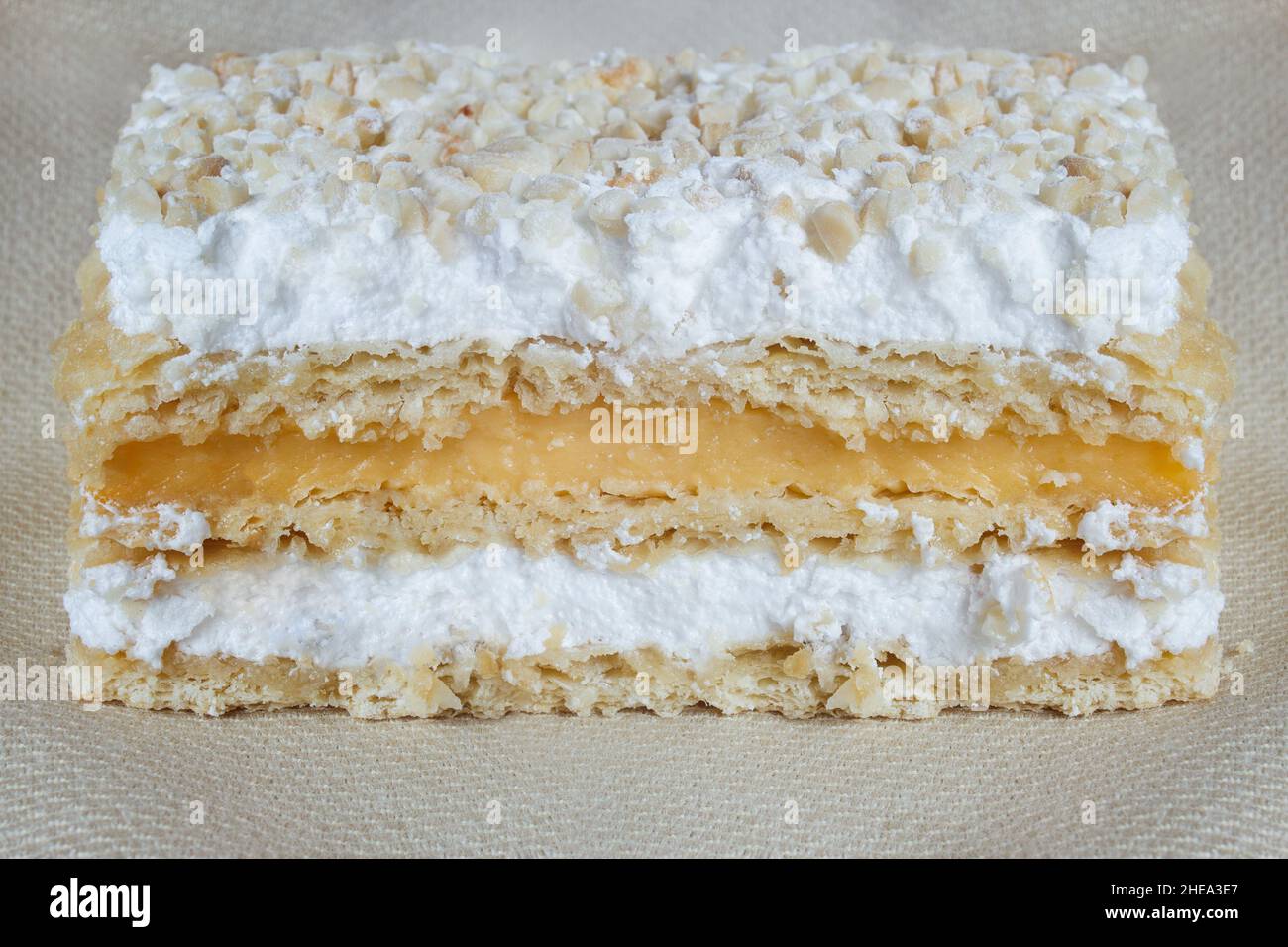 Nahaufnahme von knusprig überlappenden Blätterteig millefeuille-Schichten, gefüllt mit Creme und Baiser, bedeckt mit gehacktem und gratin Almo Stockfoto