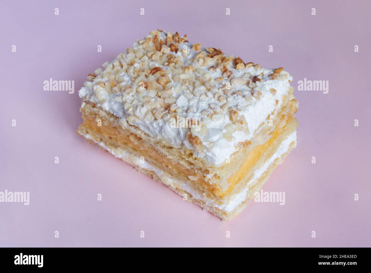 Millefeuille aus Blätterteig und gefüllt mit Backcreme und Baiser. Das Dessert wird mit gerösteten gehackten Mandeln und Puderzucker auf CO gekrönt Stockfoto