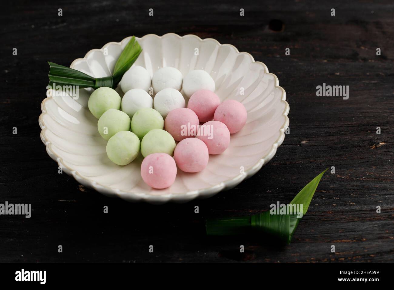 Rohe rote, grüne und weiße Tangyuan-Kumpelbälle auf Holztisch-Hintergrund für das Winteressen am Solstice Festival. Stockfoto