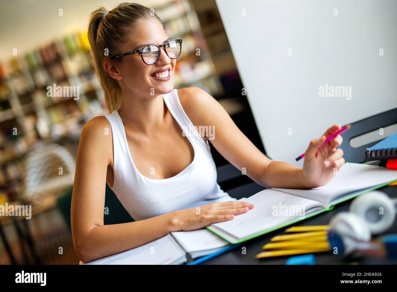 Porträt einer müden jungen Frau, die in einer Bibliothek studiert. Bildung Studie Teenager-Konzept Stockfoto