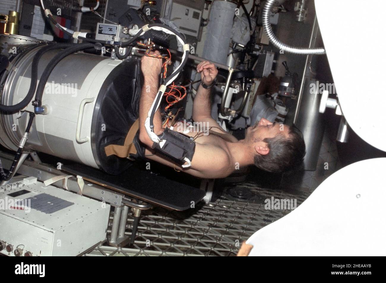 (Juli-September 1973) --- Wissenschaftler-Astronaut Owen K. Garriott, Wissenschaftspilot der Skylab 3-Mission, liegt im Unterkörper-Unterdruck-Gerät im Arbeits- und Experimentierbereich des Orbital Workshop (OWS) Crew Quarters des Skylab-Raumstation-Clusters in der Erdumlaufbahn. Dieses Bild wurde mit einer handgehaltenen Nikon-Kamera 35mm aufgenommen. Die Astronauten Garriott, Alan L. Bean und Jack R. Lousma blieben 59 Tage lang mit der Skylab-Raumstation im Orbit und führten zahlreiche medizinische, wissenschaftliche und technische Experimente durch. Das Experiment LBNPD (MO92) soll Informationen über die Zeit liefern Stockfoto