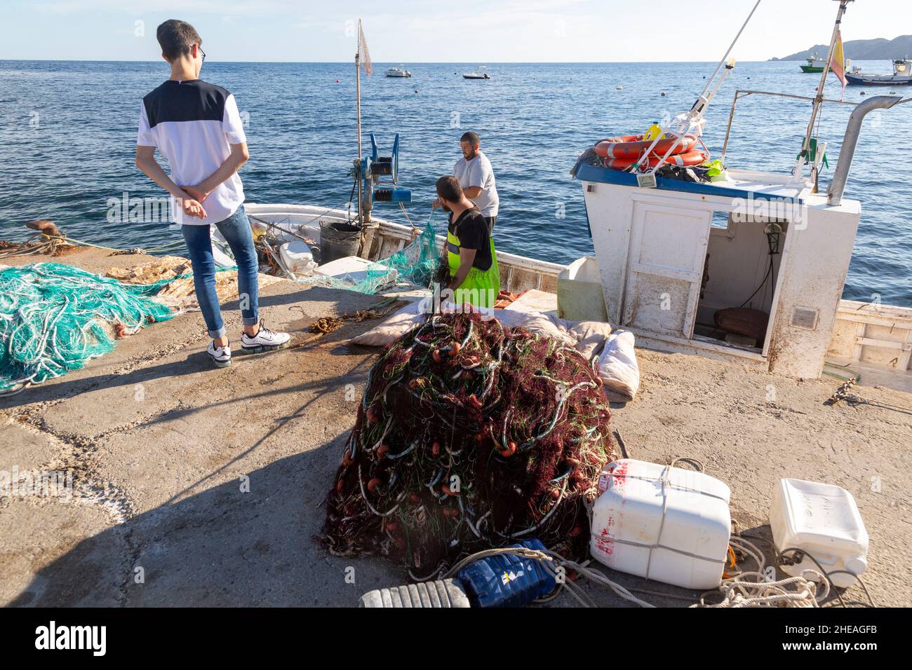 Fischer arbeiten mit Netzen auf dem Boot Isleta del Moro, Naturpark Cabo de Gata, Almeria, Spanien Stockfoto