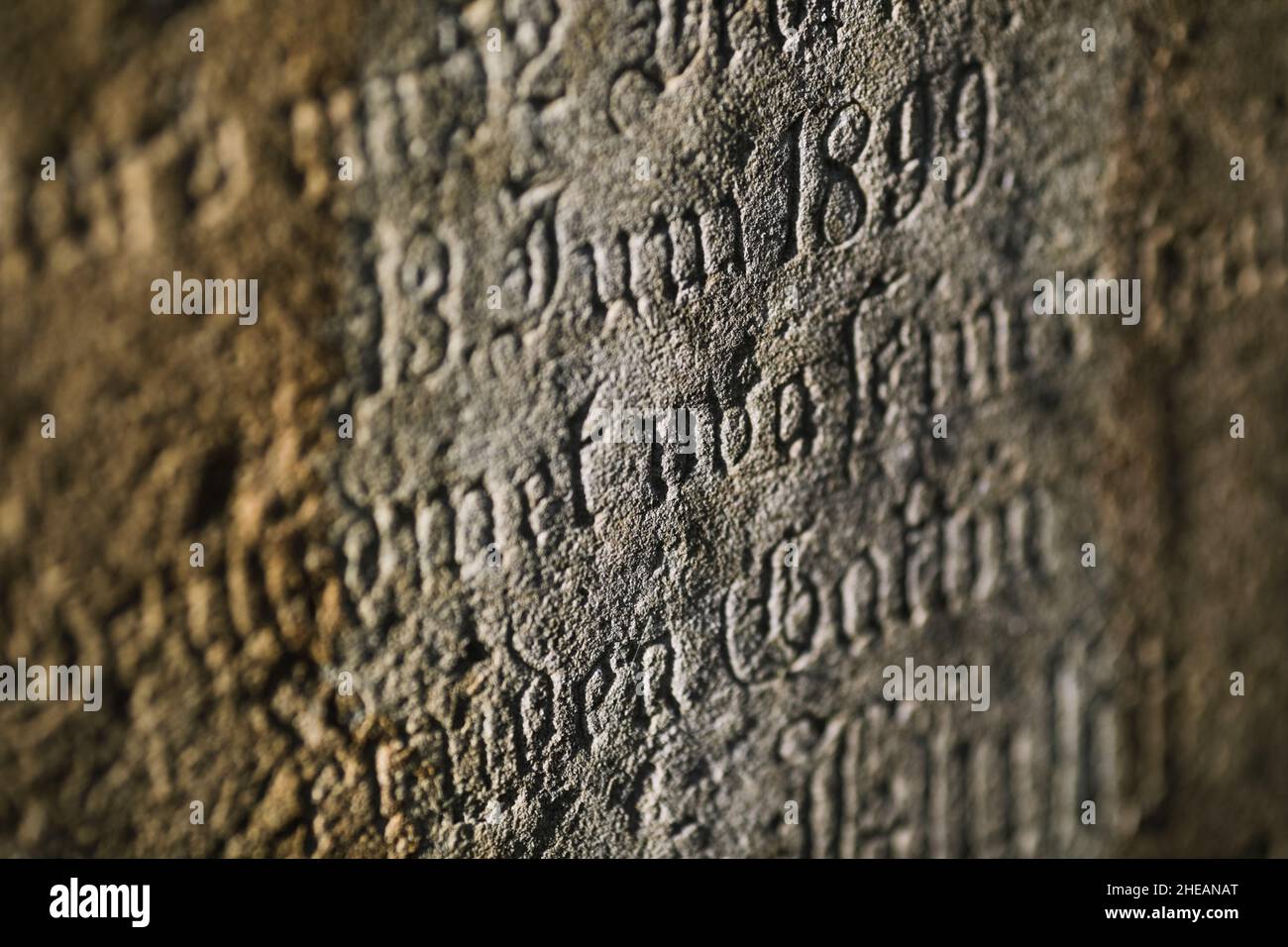 Sighisoara, Rumänien - 30. Oktober 2021: Details zur geringen Schärfentiefe (selektiver Fokus) mit dem Text in alter deutscher Sprache und Schriften auf einem Grab. Stockfoto