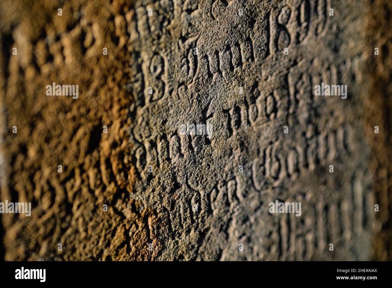 Sighisoara, Rumänien - 30. Oktober 2021: Details zur geringen Schärfentiefe (selektiver Fokus) mit dem Text in alter deutscher Sprache und Schriften auf einem Grab. Stockfoto