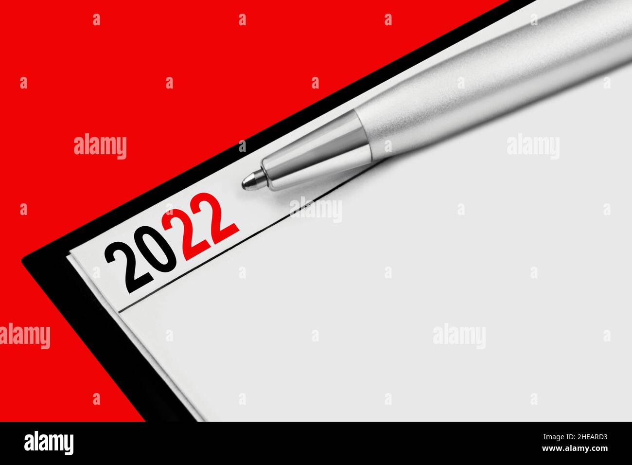 Kalender 2022 und Bleistift auf rotem Hintergrund Stockfoto
