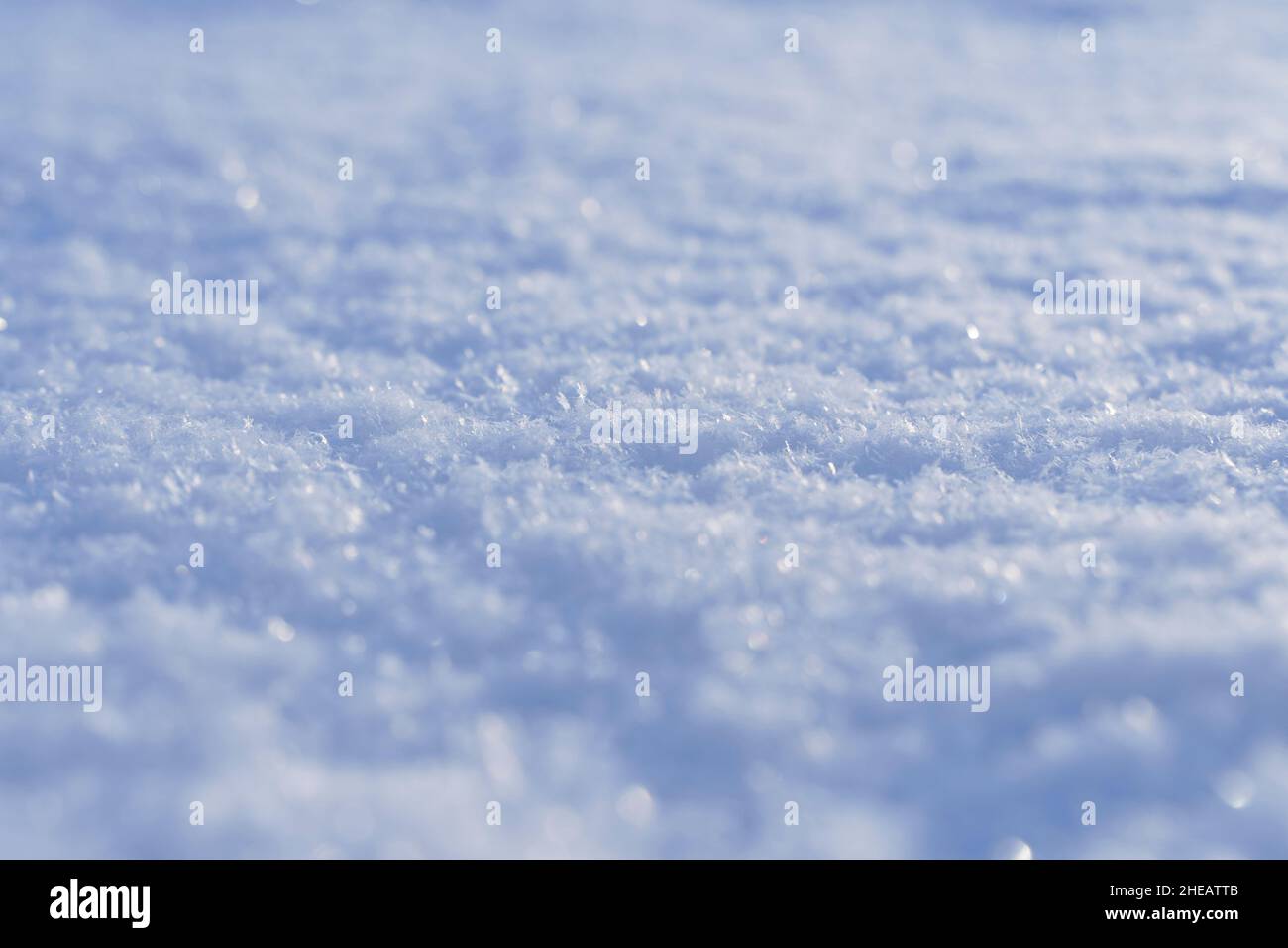 Schneebedeckter Texturhintergrund und Schneeoberfläche im Winter unter der Sonne an einem klaren frostigen Tag. Hochwertige Fotos Stockfoto