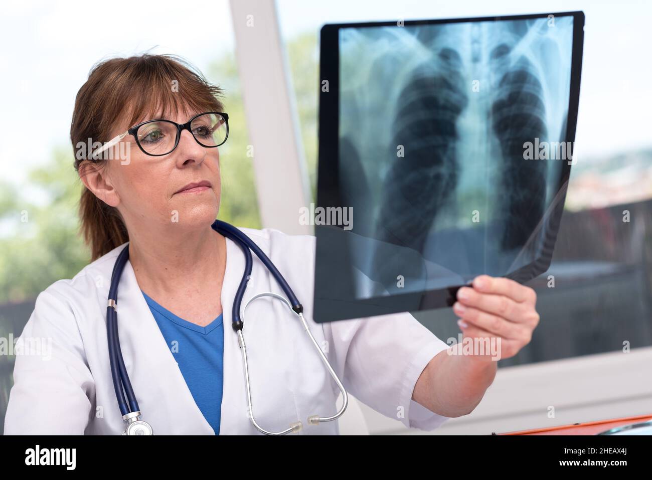Ärztin, die Röntgenbericht in der Arztpraxis untersucht Stockfoto