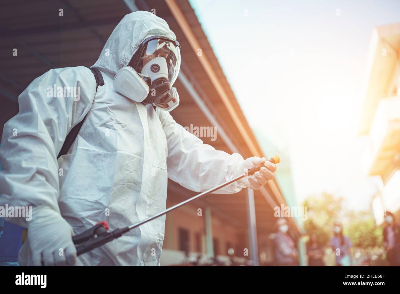 Gesundheitshelfer tragen PSA und sprühen Desinfektionsmittel, um die Ausbreitung von Keimen oder Coronaviren zu verhindern. Stockfoto