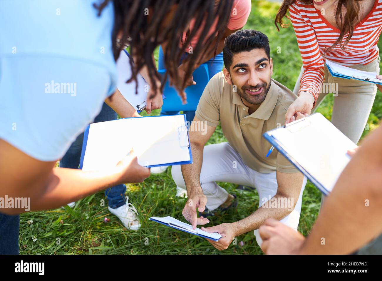 Jugendliche diskutieren bei einem Treffen im Freien über die Strategie für ein Spiel im Freien Stockfoto