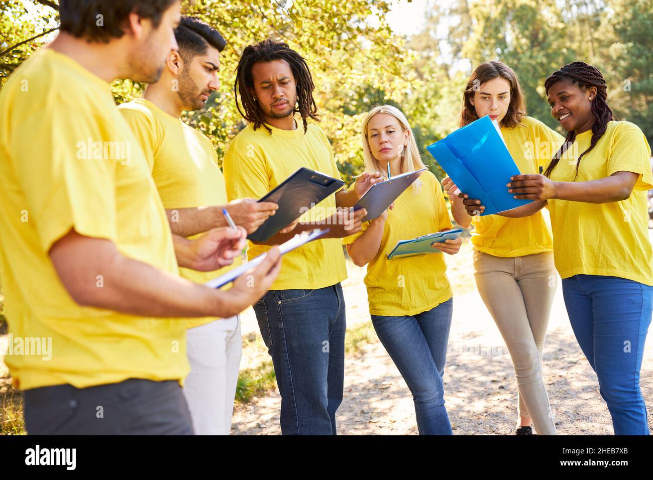 Junges multikulturelles Start-up-Team mit Clipboard Brainstorming in der Natur Stockfoto