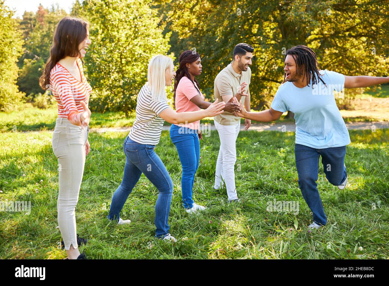 Junge Menschen geben im Sommer im Park hohe fünf für Motivation und Teambildung Stockfoto