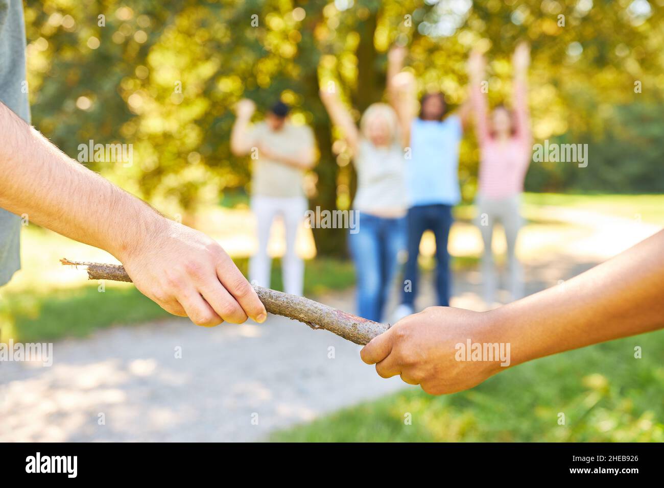 Übergabe des Stabes im Staffellauf als Teambuilding-Übung im Sommer in der Natur Stockfoto