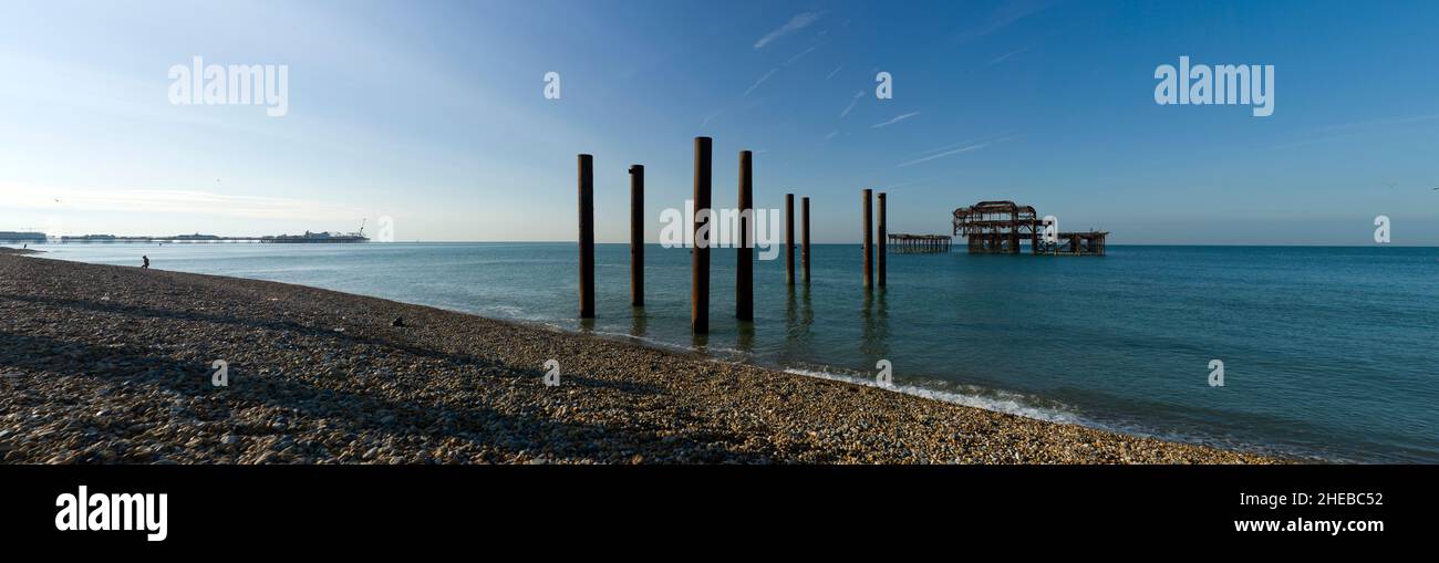 Brighton Piers, Sussex, England, Großbritannien. Juli 2014 die Überreste des ausgebrannten West Pier mit 'Brighton Pier' ( war Palace Pier ) im Hintergrund. Stockfoto