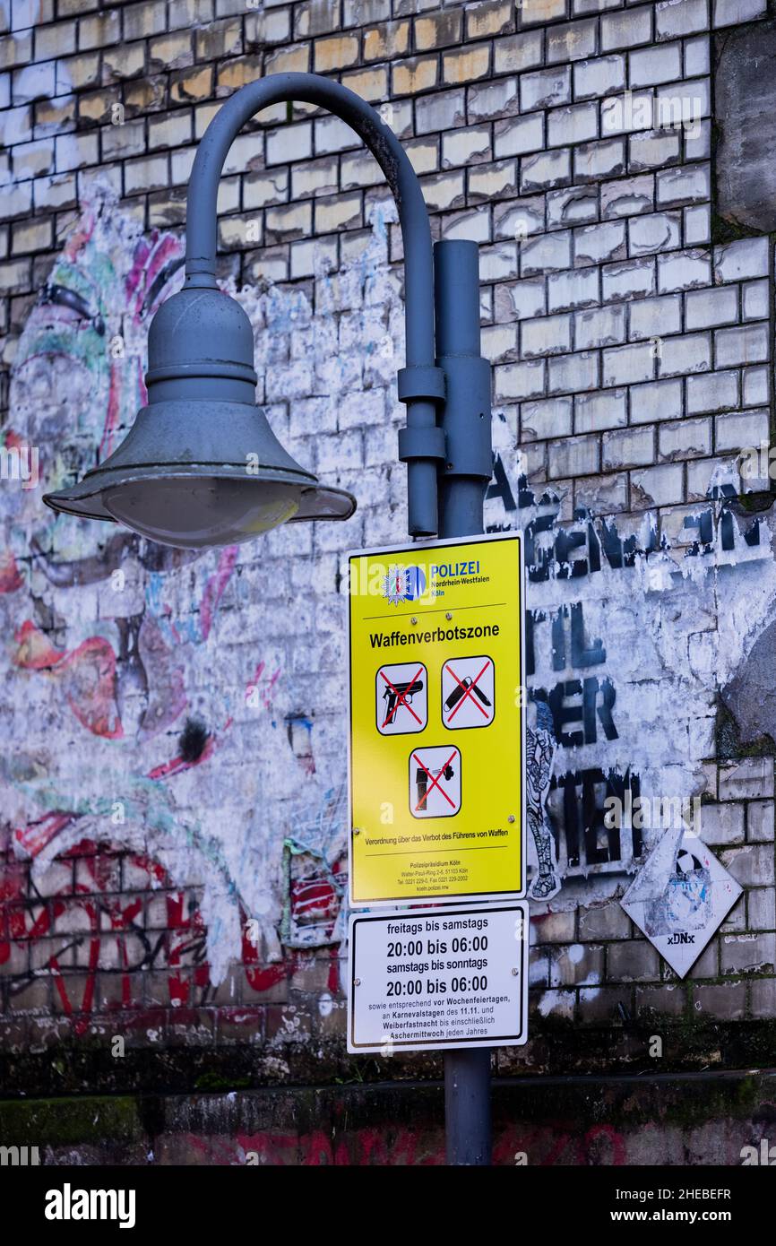 Köln, Deutschland. 10th Januar 2022. Ein Polizeischild weist auf eine Waffenvernichtungszone im Ausgehviertel Zülpicher Straße hin. Die Zonen gelten jeden Freitag- und Samstagabend von 8 Uhr bis 6 Uhr am nächsten Morgen - sowie vor und an Feiertagen und an Karneval. Elektroschocker, Messer mit einer Klingenlänge von mehr als vier Zentimetern, Reizgas und Pfefferspray dürfen dann nicht mehr mitgeführt werden. Quelle: Rolf Vennenbernd/dpa/Alamy Live News Stockfoto