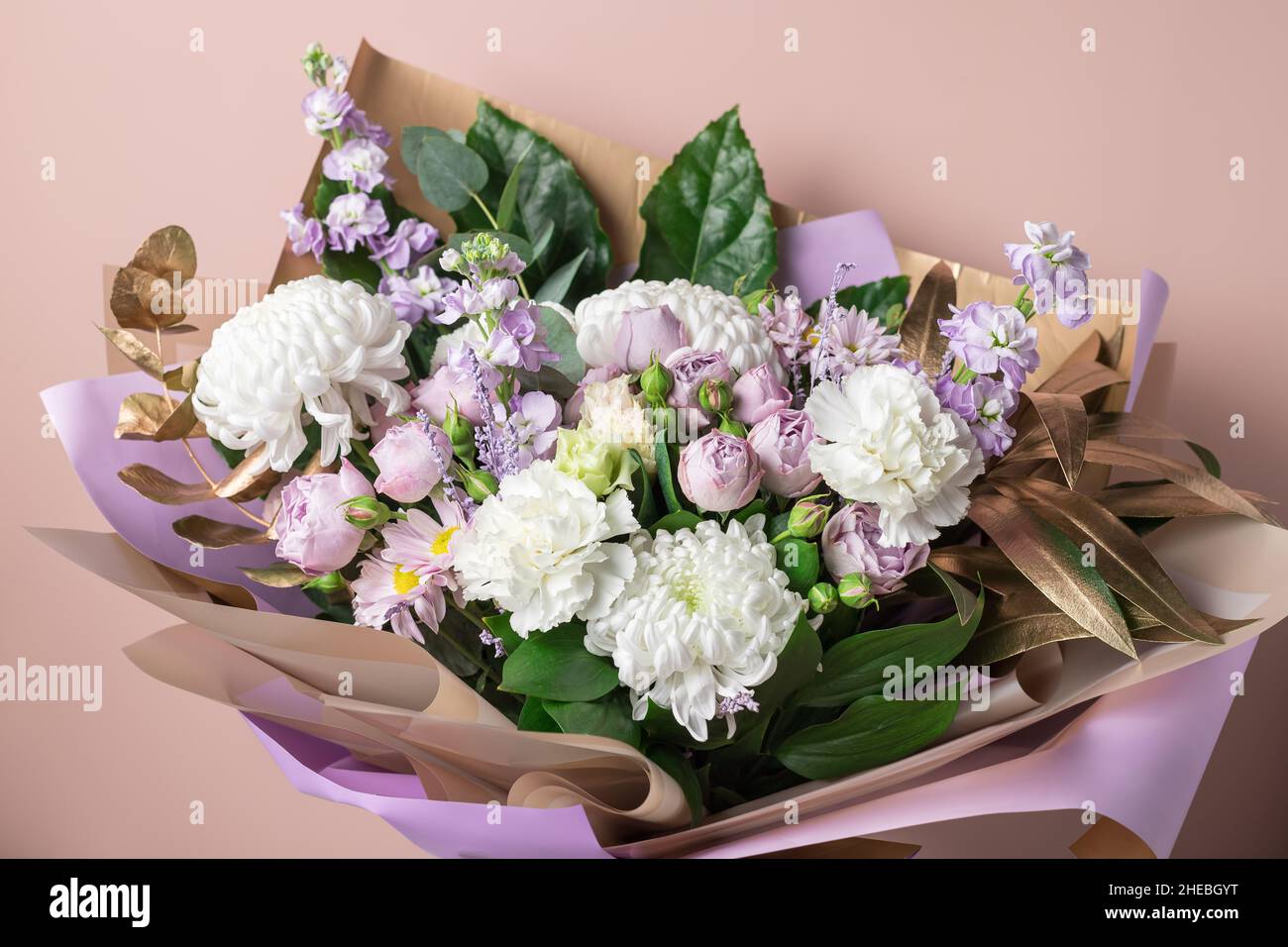 Schönes Bouquet mit Chrysanthemen, Rosen, Nelken auf farbigem Hintergrund Stockfoto