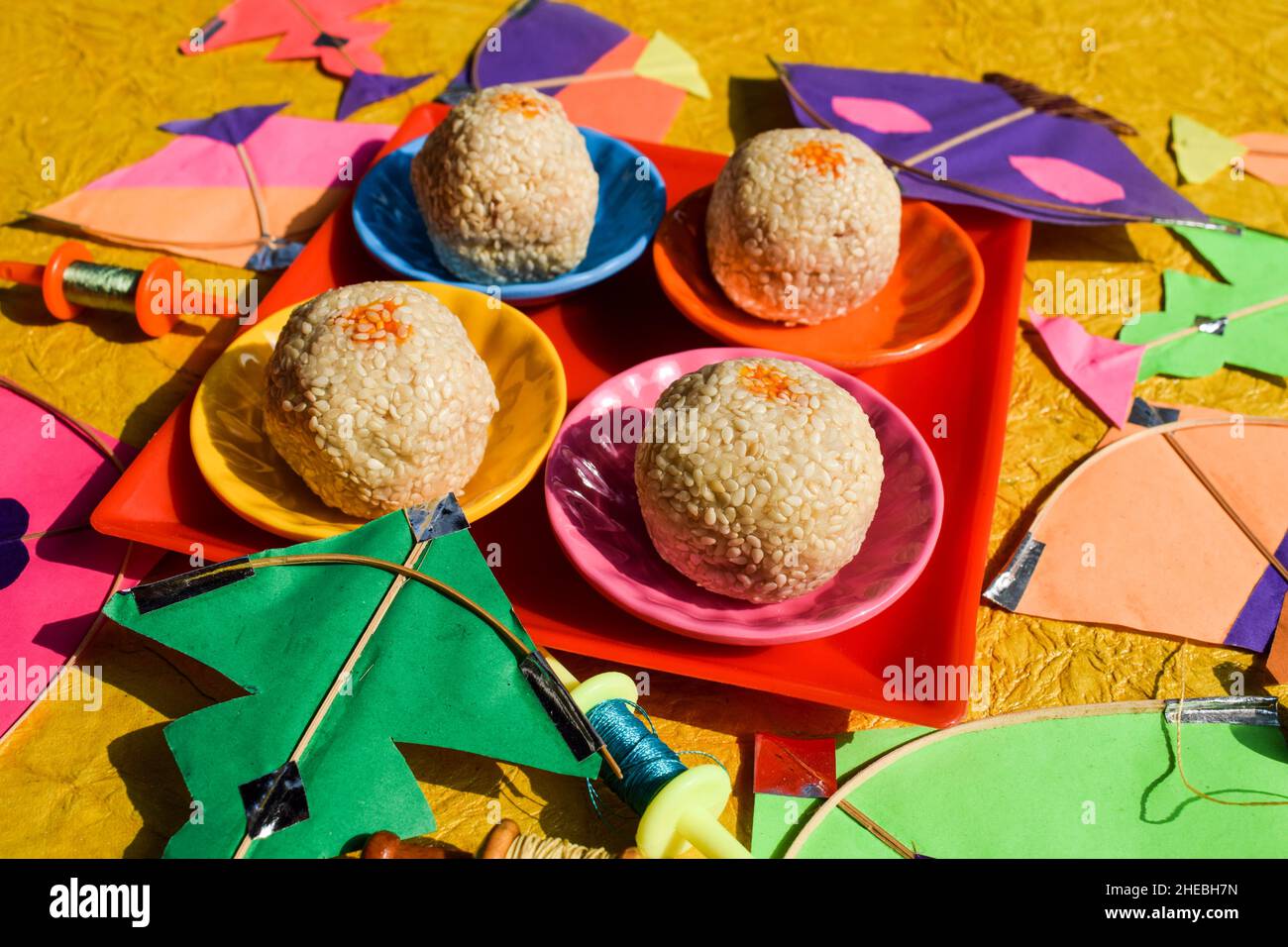 Til laddu oder Sesam ladoo makarsankranti Thema spezielle sankranti traditionelle Süßigkeiten mit bunten Drachen Hintergrund Grußwünsche Stockfoto