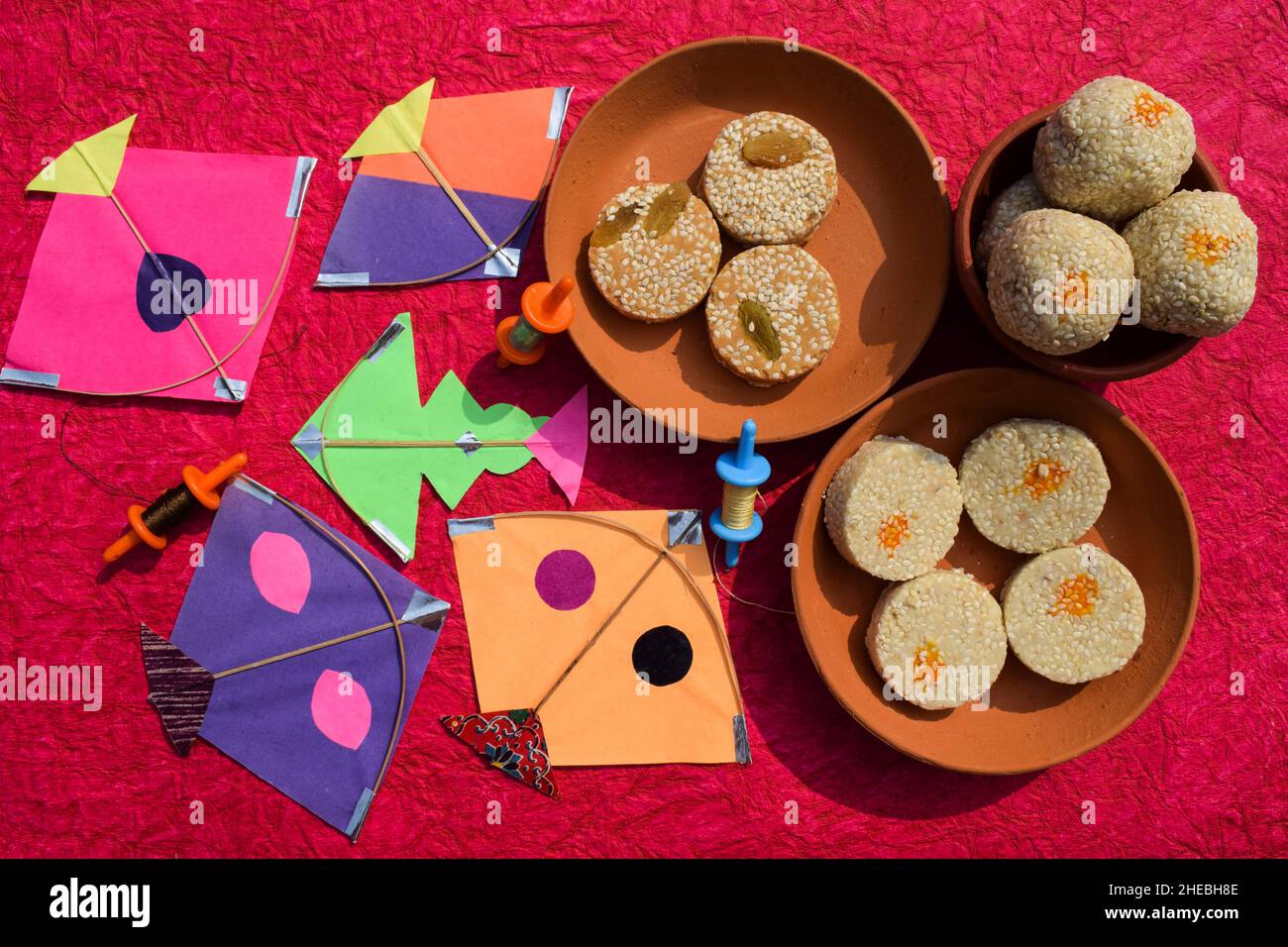 Til Gul oder süße weiße Sesamsamen Laddu mit Drachen und Phirki. Makar sankranti Festival Food Hintergrund. Til baati mit Laddo Stockfoto