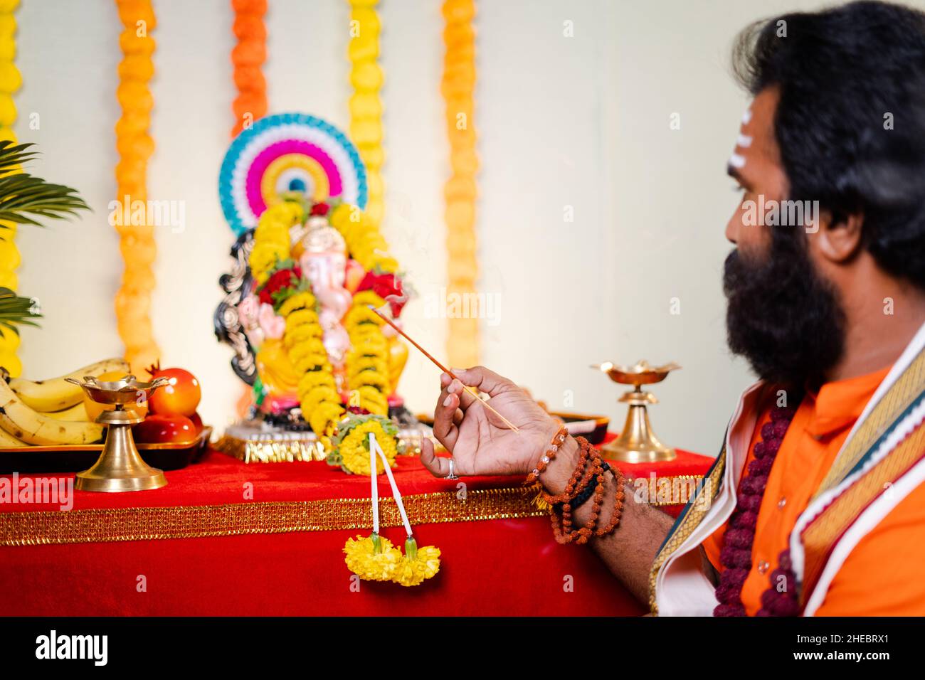 Konzentrieren Sie sich auf die Hand Heiliger gott Mann oder indischen Priester aarti anbieten, indem Hymnen vor lord ganesh Idol während der Festfeier zu Hause singen - Stockfoto