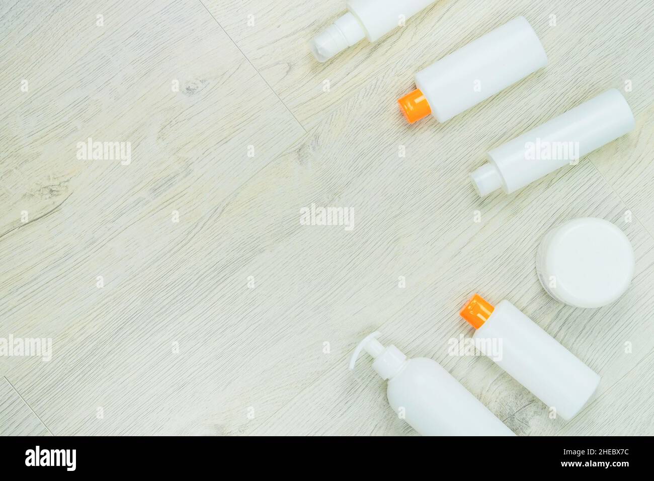 Plastikflaschen mit Kosmetik auf hellem Holzhintergrund. Flaschen Polyethylen hoher Dichte für das Recycling, den Planeten zu retten.Draufsicht, Platz für Text. Stockfoto