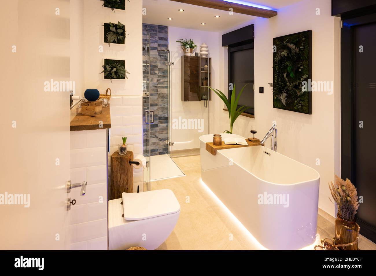 Modernes Badezimmer mit freistehender Badewanne, modernen Armaturen und indirekter LED-Beleuchtung Stockfoto