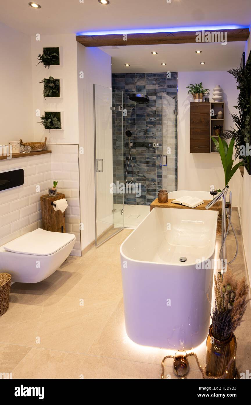 Modernes Badezimmer mit freistehender Badewanne, modernen Armaturen und indirekter LED-Beleuchtung Stockfoto