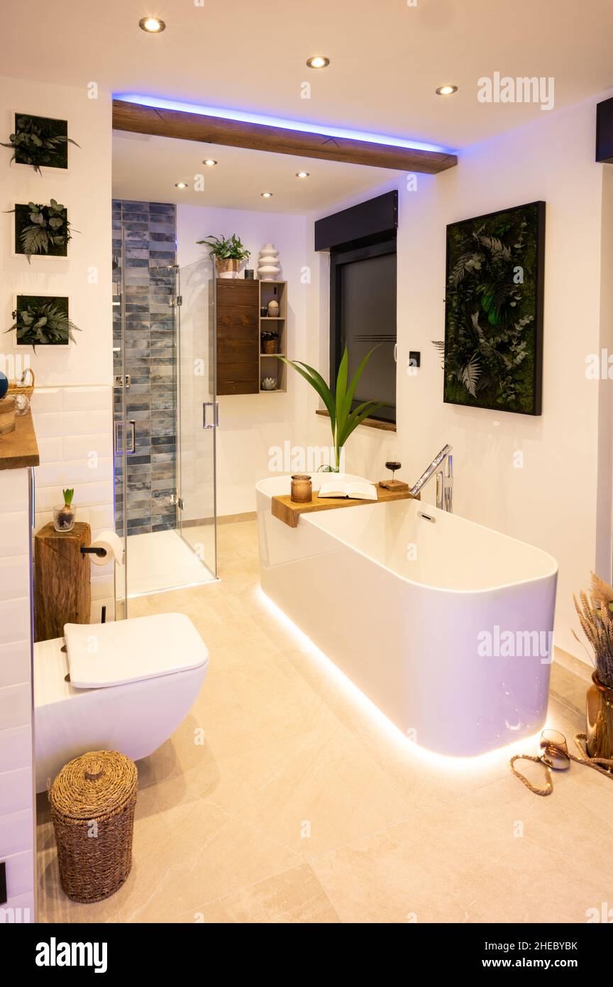 Modernes Badezimmer mit freistehender Badewanne, modernen Armaturen und indirekter LED-Beleuchtung Stockfoto