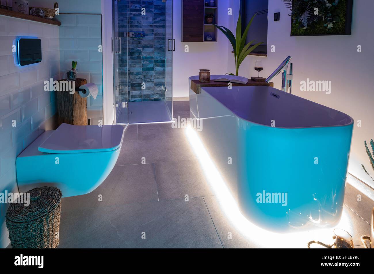 Modernes Badezimmer mit freistehender Badewanne, modernen Armaturen und LED-Umgebungsbeleuchtung Stockfoto