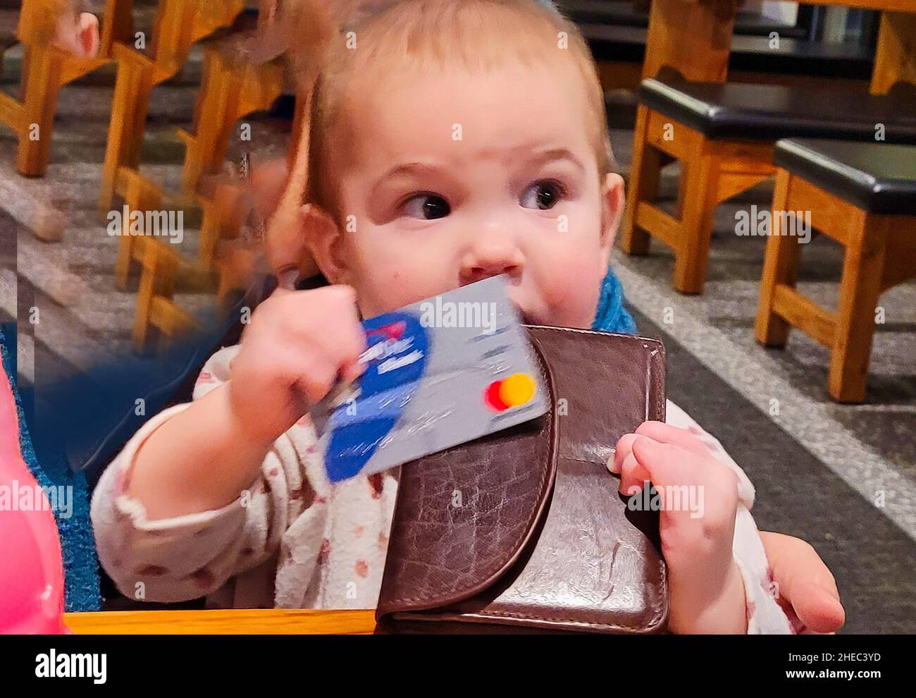 Ein einjähriges Kind, das ihre MasterCard benutzt, um für ein Essen im Restaurant zu bezahlen Stockfoto