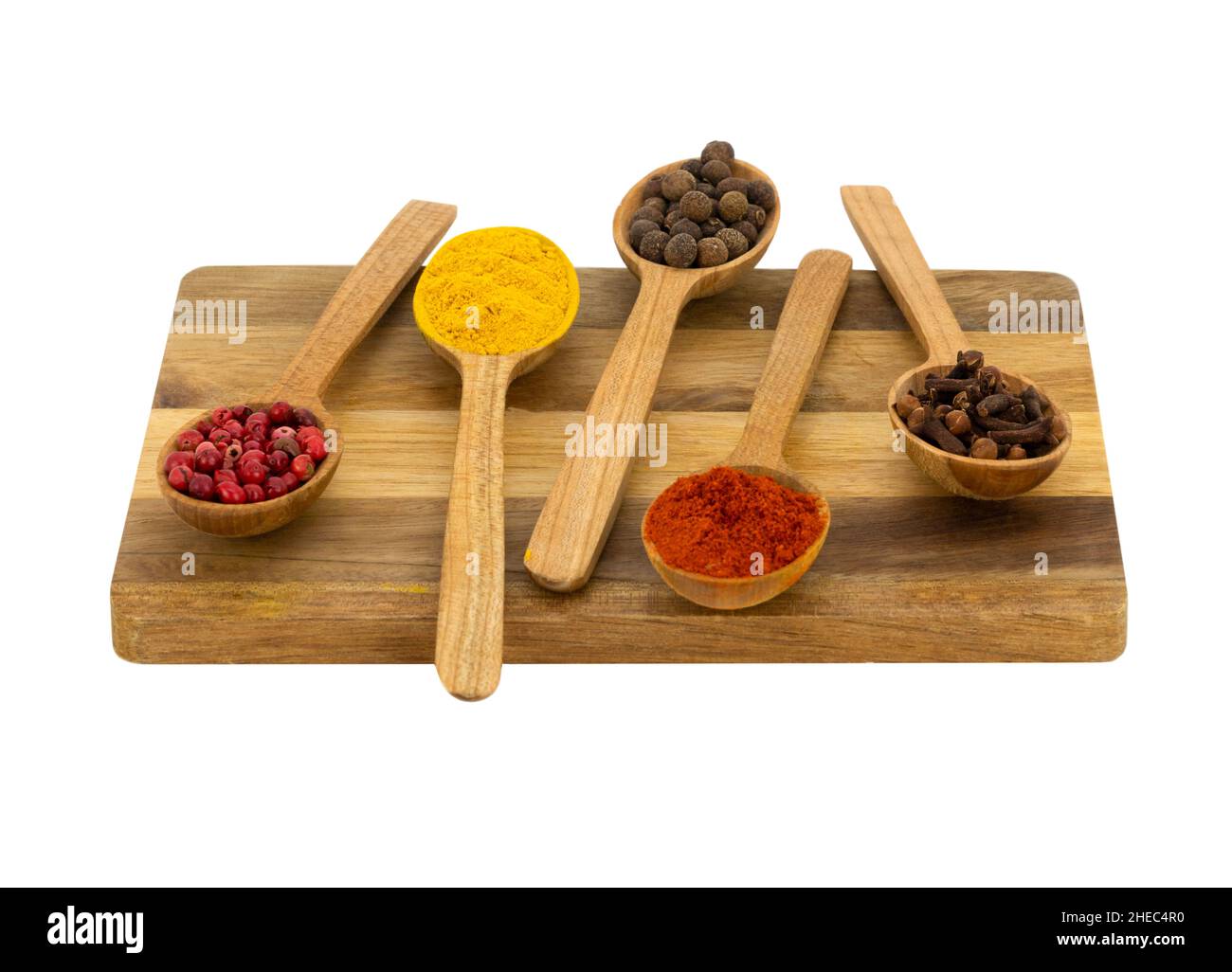 Weißer Hintergrund, isoliert, fünf Löffel mit Gewürzen liegen auf Holzschneidebrett Stockfoto