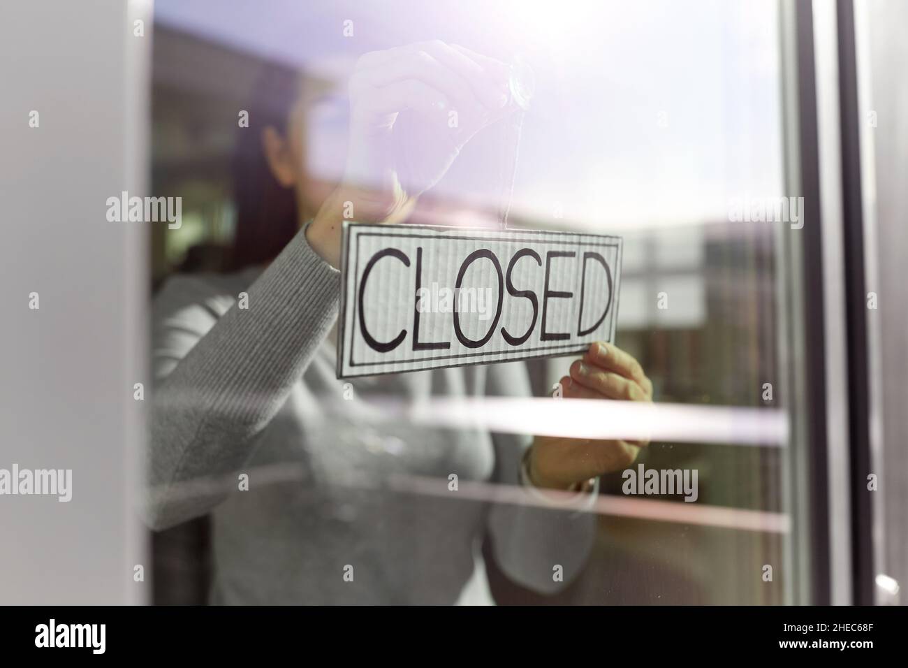 Frau hängend Banner mit geschlossenen Wort an der Tür Stockfoto