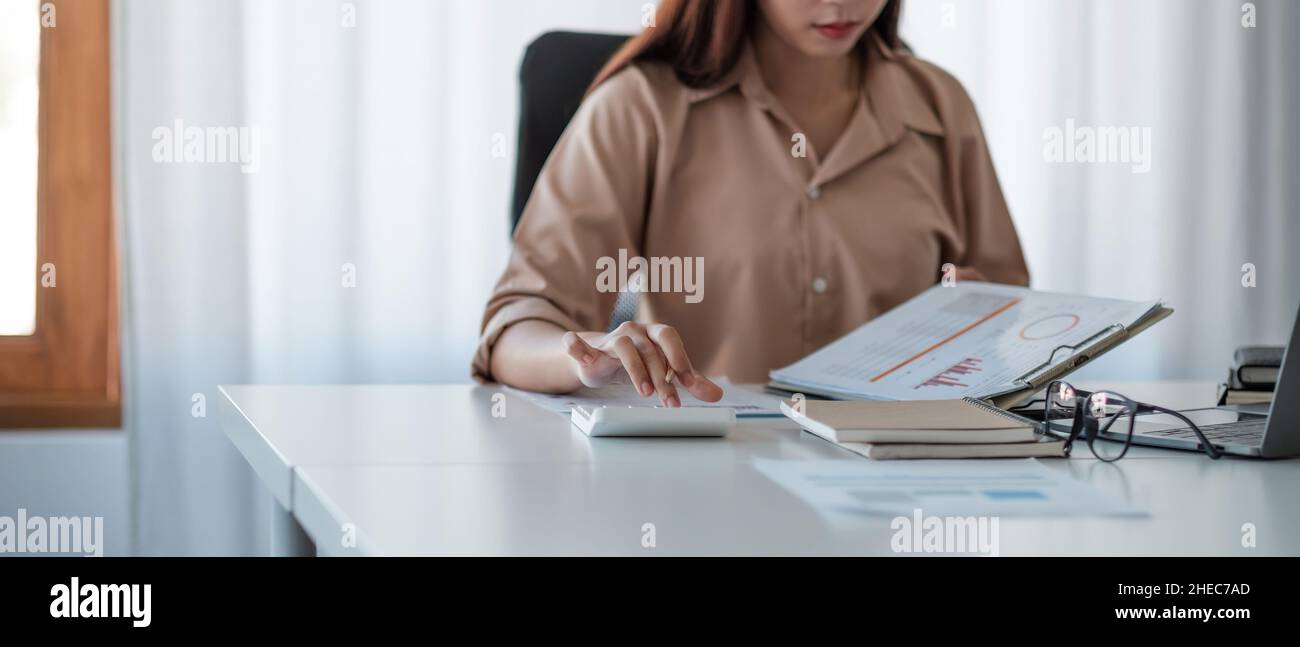 Geschäftsfrau, die im Finanz- und Rechnungswesen arbeitet, analysiert das Finanzbudget mit Rechner und Papierkram im Büro. Stockfoto