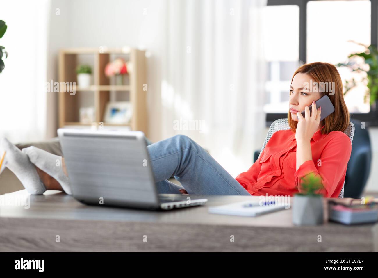 Frau, die im Heimbüro auf dem Smartphone anruft Stockfoto