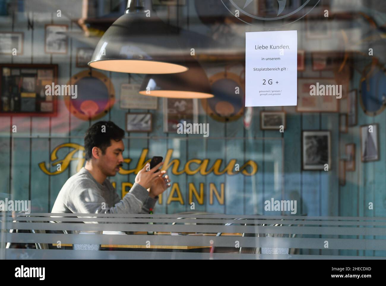 (220110) -- FRANKFURT, 10. Januar 2022 (Xinhua) -- Ein Kunde wartet darauf, in einem Restaurant mit einem Schild serviert zu werden, das die Menschen über die Anti-Epidemie-Regeln von 2G+ gegen COVID-19 in Frankfurt am 10. Januar 2022 informiert. Die 7-tägige COVID-19-Inzidenzrate in Deutschland pro 100.000 Einwohner stieg weiter an und erreichte 375,7, gegenüber 362,7 am Vortag, berichtete das Robert Koch-Institut (RKI) für Infektionskrankheiten am Montag. Am vergangenen Freitag hatten sich die deutsche und die Landesregierung auf eine sogenannte 2G-plus-Regel für den Gastronomiebereich geeinigt, die den Zugang zu geimpften und wiedergeborgenen Menschen einschränkt Stockfoto