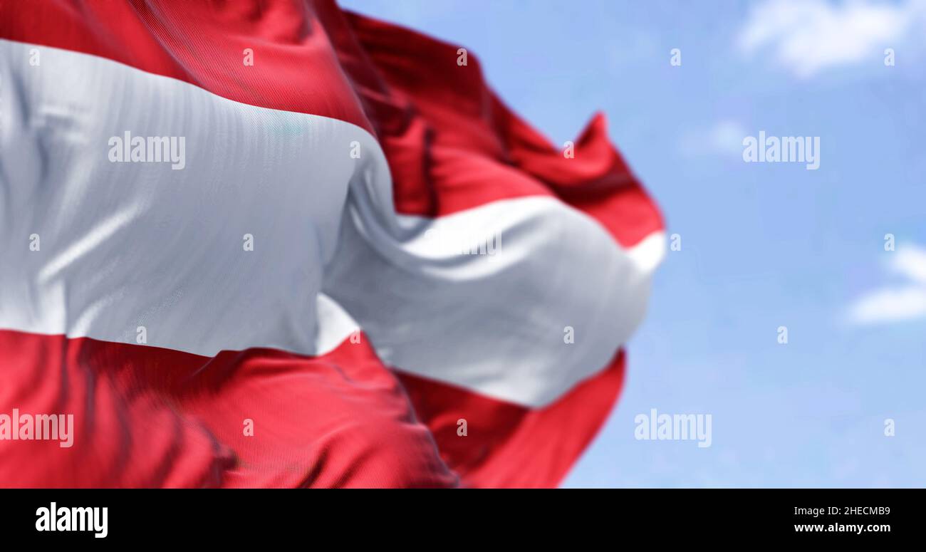 Detail der Nationalflagge Österreichs, die an einem klaren Tag im Wind winkt. Demokratie und Politik. Europäisches Land. Selektiver Fokus. Stockfoto