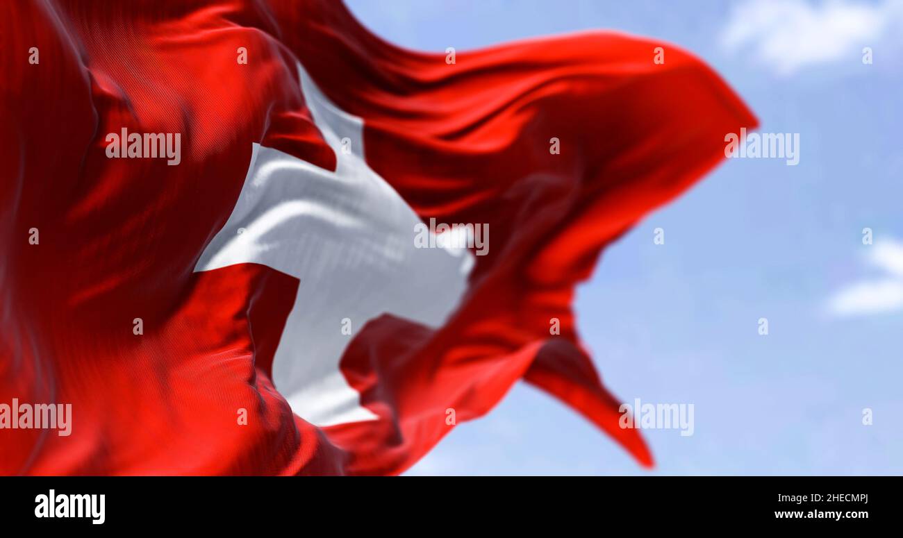 Detail der Nationalflagge der Schweiz, die an einem klaren Tag im Wind winkt. Demokratie und Politik. Europäisches Land. Selektiver Fokus. Stockfoto