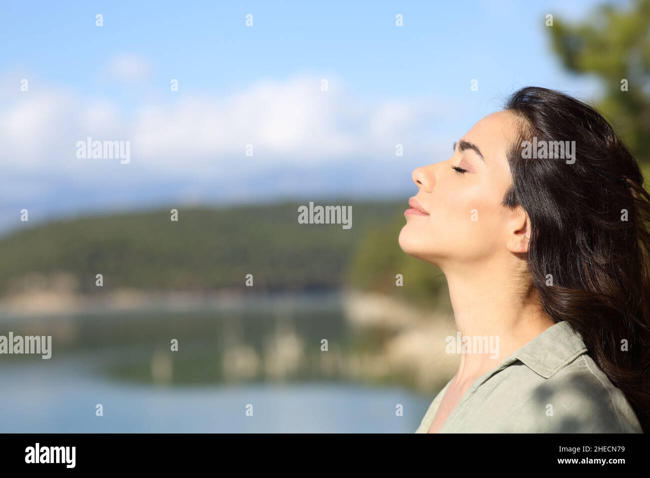 Seitenansicht Porträt einer entspannten Frau, die an einem sonnigen Tag frische Luft in einem See atmet Stockfoto