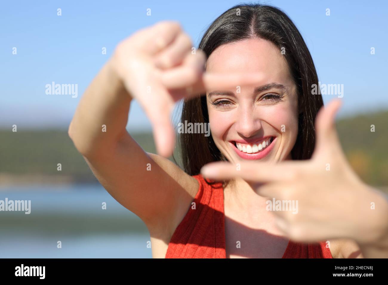 Vorderansicht Porträt einer glücklichen Frau, lächelnd, mit den Händen an der Kamera Stockfoto