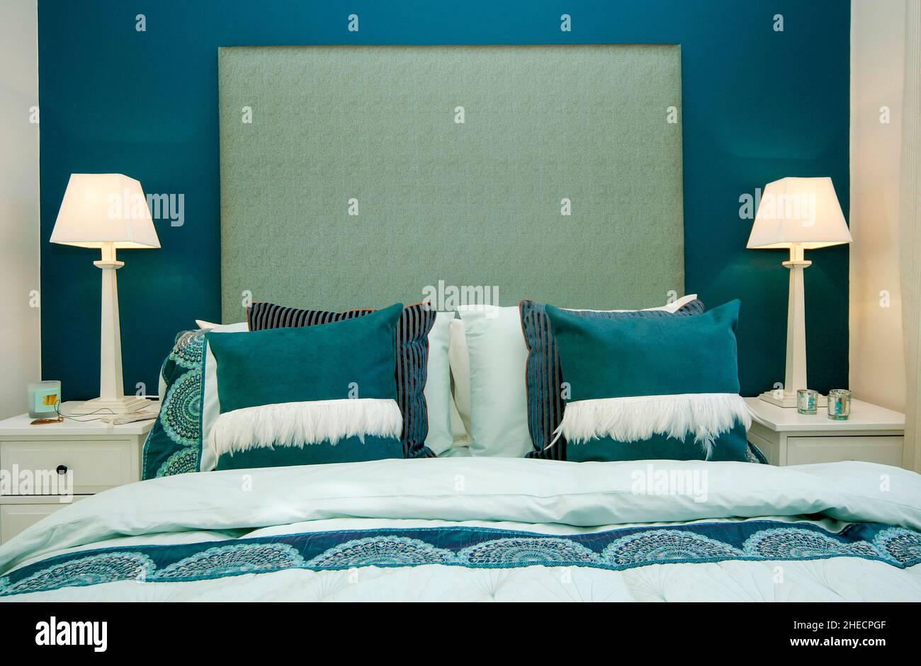 Doppelbett mit blaugrünen Kissen, Bettüberwurf, Bettbezug, Nachttischlampen, modern, Lifestyle. Stockfoto