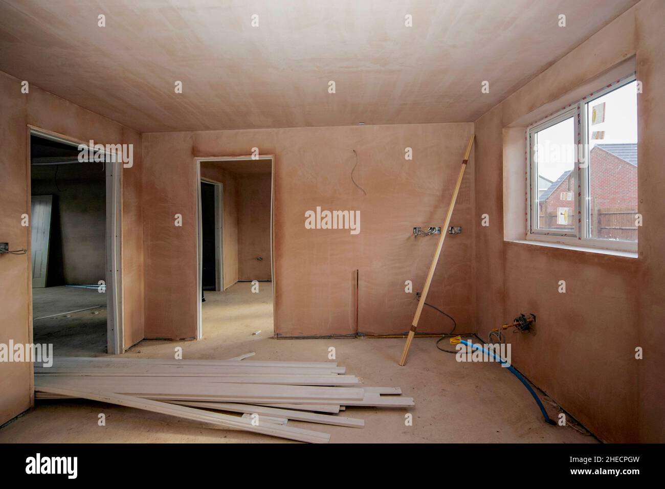 Frisch verputzte Innenausstattung eines modernen Neubau-Hauses, Türen bereit zum Einbau, Verkabelung unvollständig, Austrocknung Stockfoto