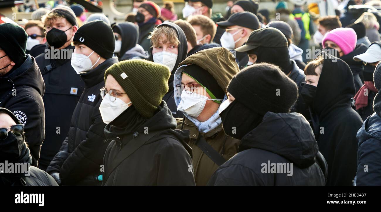 Braunschweig, 8. Januar 2022: Junge Menschen tragen Masken gegen Corona-Ansteckung und Mützen auf ihren Köpfen ohne Abstand bei einer Demonstrationsdemonstration Stockfoto