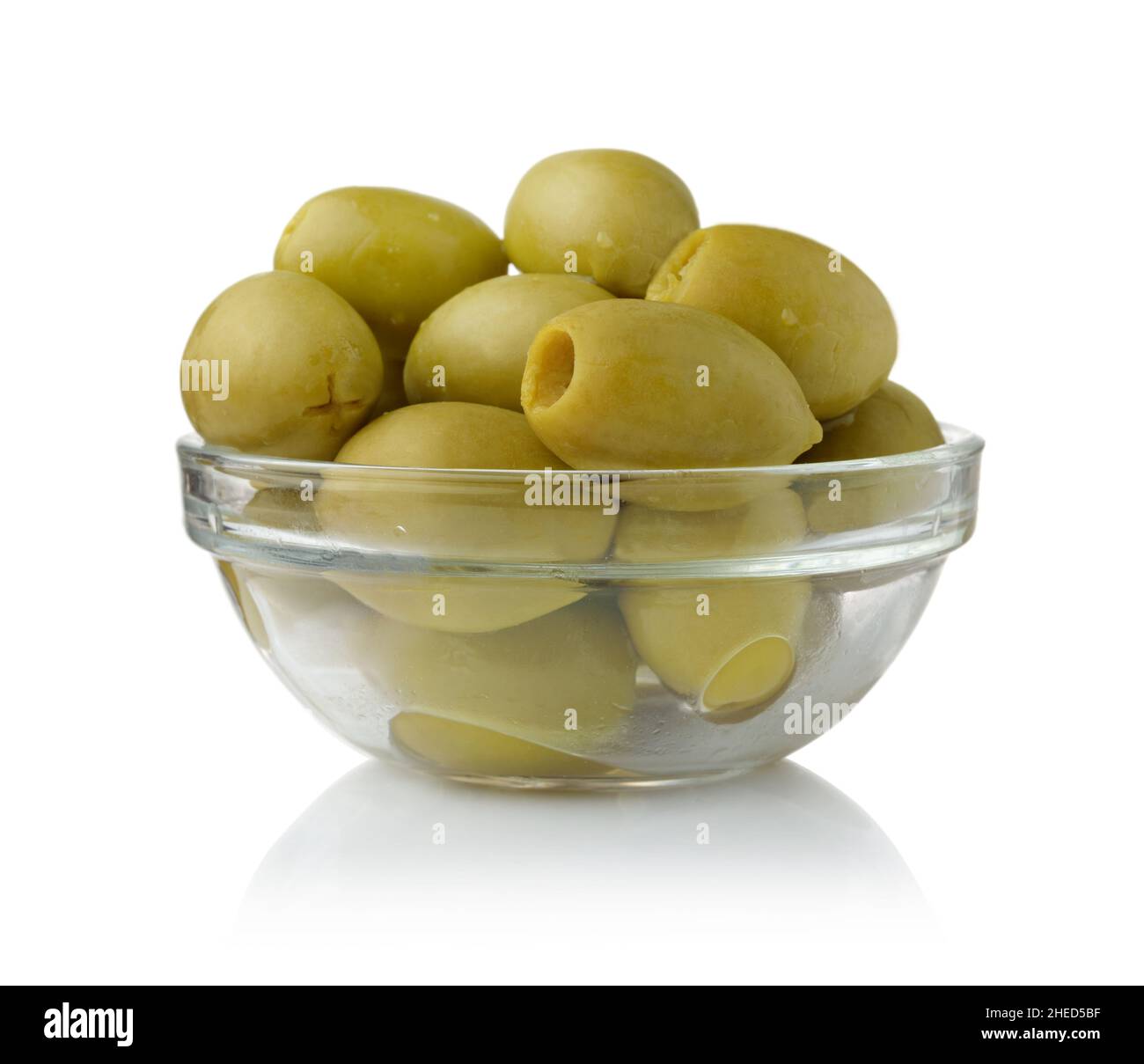 Grüne große Oliven in einer Glasschüssel isoliert auf weiß. Stockfoto