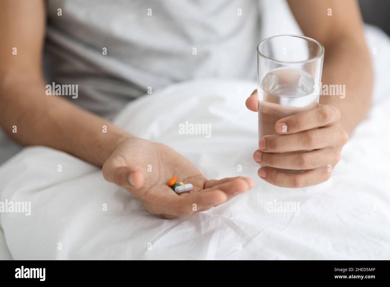Medizinische Behandlung. Nicht Erkennbarer Mann Hält Haufen Von Pillen Und Glas Mit Wasser Stockfoto
