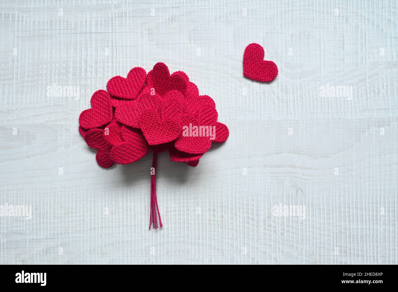 Gestrickte Liebesherzen auf grauem Hintergrund, Valentinstags-Postkarten-Konzept Stockfoto