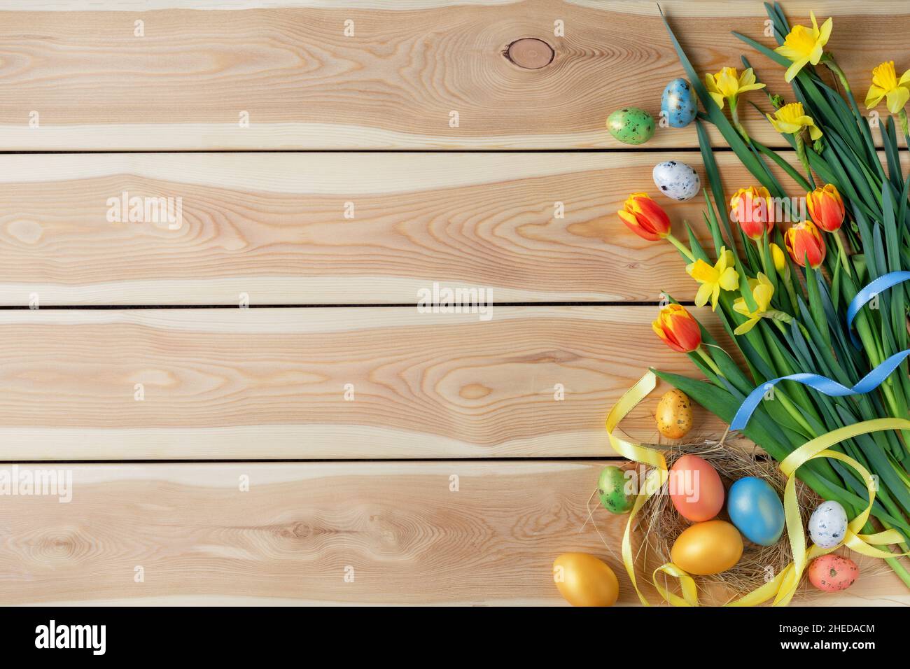 Frohe Ostern Karte. Herzlichen Glückwunsch zu ostern Hintergrund. Ostereier und Blumen auf Holzhintergrund. Stockfoto