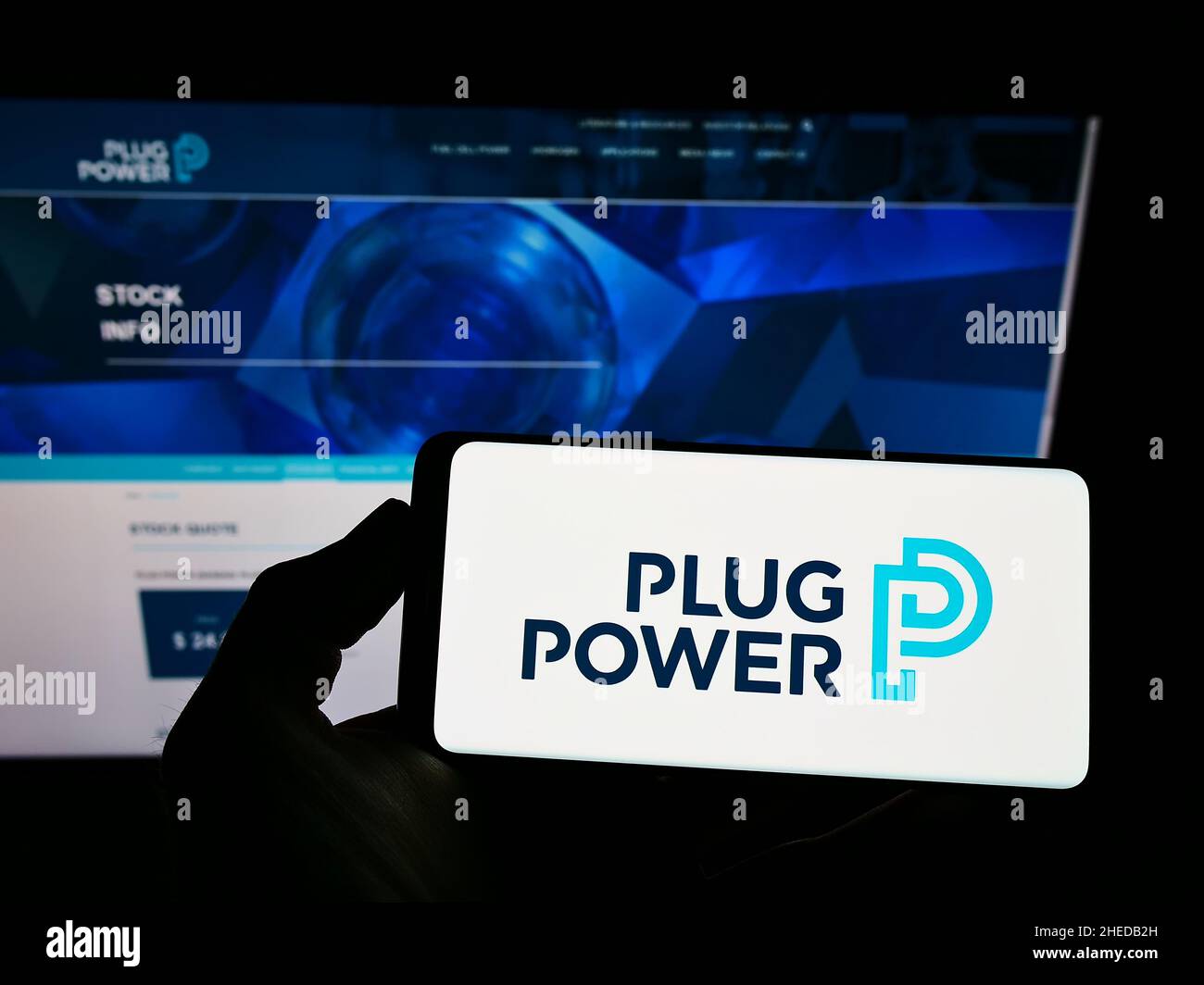 Person, die das Smartphone mit dem Logo des US-amerikanischen Wasserstoffbrennstoffzellenunternehmens Plug Power Inc. Auf dem Bildschirm vor der Website hält. Konzentrieren Sie sich auf die Telefonanzeige. Stockfoto