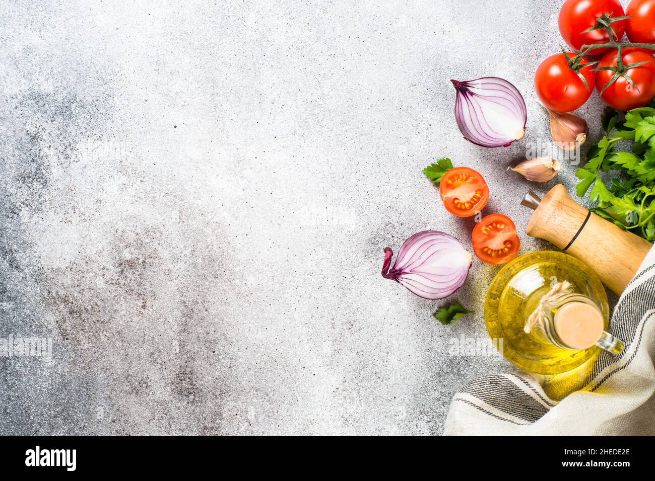 Olivenöl, Kräuter und Gemüse am Steintisch von oben. Stockfoto