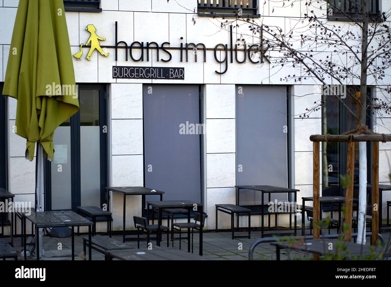 Stuttgart, 31. Dezember 2021: Burger-Grillbar von außen. Leere Tische und Bänke mit gefaltetem Sonnenschirm. Der Name stammt aus einem Märchen. Stockfoto